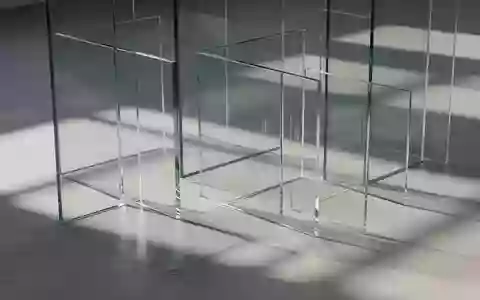 Eine Reihe halbtransparenter Glasscheiben wirft geometrische Schatten auf einen schlichten Betonboden, symbolisch für Transparenz und Regulierung. - Foto: über boerse-global.de