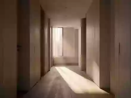 Ein minimalistischer Flur mit natürlichem Lichteinfall und Schattenwurf auf einem Holzboden in einem modernen Wohnhaus. - Foto: über boerse-global.de