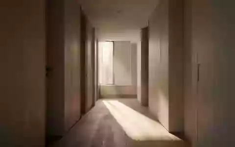 Ein minimalistischer Flur mit natürlichem Lichteinfall und Schattenwurf auf einem Holzboden in einem modernen Wohnhaus. - Foto: über boerse-global.de