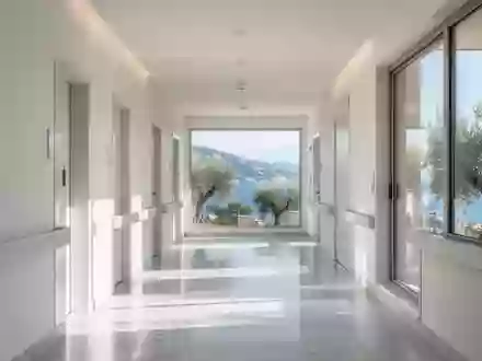 Ein heller, moderner Krankenhausflur in Ligurien mit Blick auf eine mediterrane Küstenlandschaft. - Foto: über boerse-global.de
