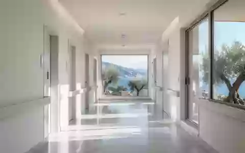 Ein heller, moderner Krankenhausflur in Ligurien mit Blick auf eine mediterrane Küstenlandschaft. - Foto: über boerse-global.de