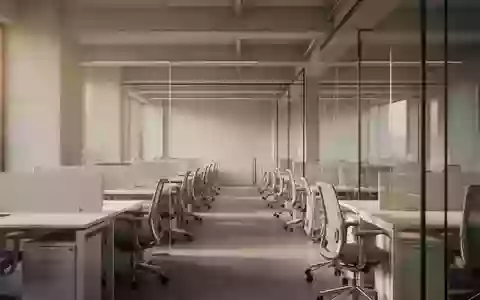 Ein minimalistisches, helles Bürogebäude mit leeren Arbeitsplätzen und architektonischen Linien bei natürlichem Lichteinfall. - Foto: über boerse-global.de