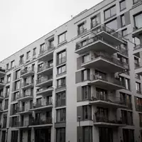 Moderne Berliner Wohnblocks vor einem bewölkten Himmel bei Tageslicht. - Foto: über boerse-global.de