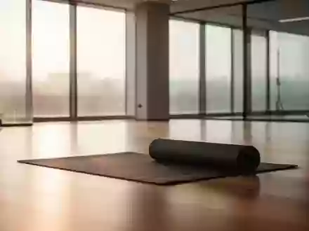 Ein minimalistischer, moderner Fitnessraum in ruhigem Morgenlicht mit einer zusammengerollten Yogamatte auf einem Holzboden. - Foto: über boerse-global.de