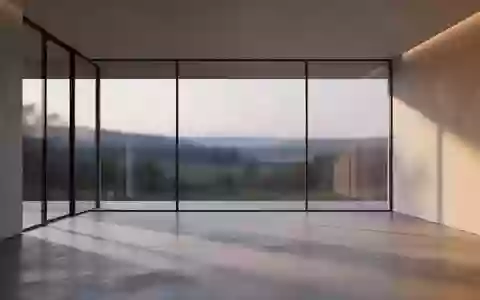 Ein minimalistischer, moderner Raum mit einer großen Glasfront und Blick auf eine ruhige Landschaft bei Dämmerung. - Foto: über boerse-global.de