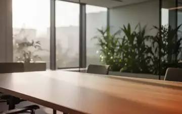 Ein minimalistischer, heller Büroraum mit natürlichem Licht und Pflanzen, der eine ruhige und gesunde Arbeitsumgebung symbolisiert. - Foto: über boerse-global.de