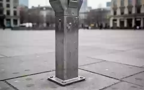 Ein einsamer Parkscheinautomat auf einem grauen Gehweg bei bewölktem Tageslicht. - Foto: über boerse-global.de