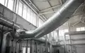 Industrielle Belüftungsanlage mit Metallrohren an einer Fabrikdecke in einer sauberen, modernen Umgebung. - Foto: über boerse-global.de