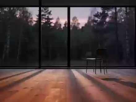 Ein minimalistischer, ruhiger Raum bei Dämmerung mit langen Schatten und Blick auf einen Wald durch ein großes Fenster. - Foto: über boerse-global.de