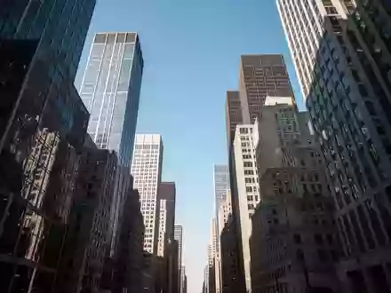 Blick nach oben in einer Straßenschlucht zwischen hohen Bürogebäuden bei klarem Tageslicht. - Foto: über boerse-global.de