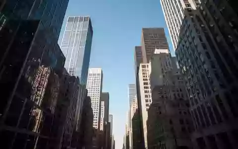 Blick nach oben in einer Straßenschlucht zwischen hohen Bürogebäuden bei klarem Tageslicht. - Foto: über boerse-global.de