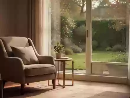 Ein ruhiger, sonnendurchfluteter Wohnbereich mit einem bequemen Sessel und einem Fenster mit Blick in einen Garten. - Foto: über boerse-global.de
