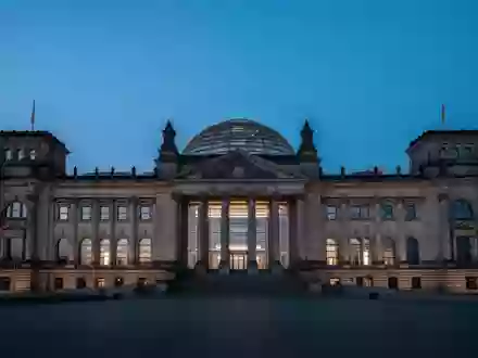 Die beleuchtete Reichstagskuppel in Berlin bei Dämmerung vor einem tiefblauen Abendhimmel. - Foto: über boerse-global.de