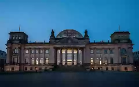 Die beleuchtete Reichstagskuppel in Berlin bei Dämmerung vor einem tiefblauen Abendhimmel. - Foto: über boerse-global.de