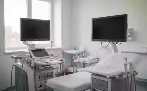 Ein minimalistisch eingerichteter, heller Untersuchungsraum in einer modernen Klinik mit medizinischen Geräten. - Foto: über boerse-global.de