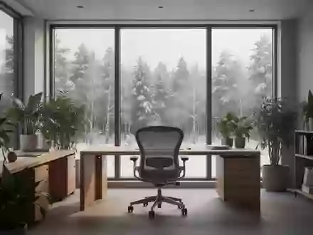 Ein minimalistisch eingerichteter, heller und ruhiger Arbeitsraum mit Blick auf eine winterliche norwegische Waldlandschaft. - Foto: über boerse-global.de