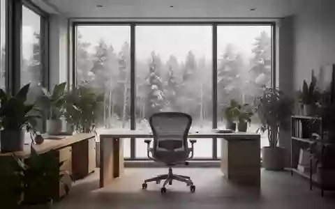 Ein minimalistisch eingerichteter, heller und ruhiger Arbeitsraum mit Blick auf eine winterliche norwegische Waldlandschaft. - Foto: über boerse-global.de