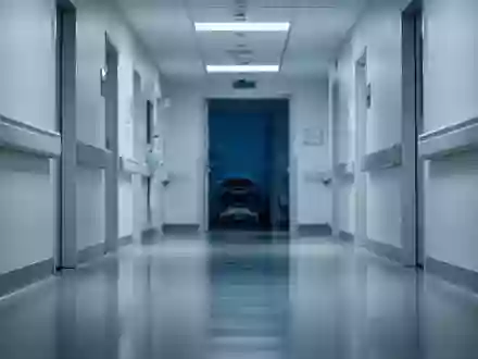 Ein leerer, steriler Krankenhausflur in kühlem, klinischem Licht mit polierten Böden und weißen Wänden. - Foto: über boerse-global.de
