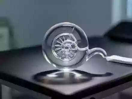 Ein gläsernes Modell der menschlichen Cochlea in einer medizinischen Umgebung bei sanfter Beleuchtung. - Foto: über boerse-global.de