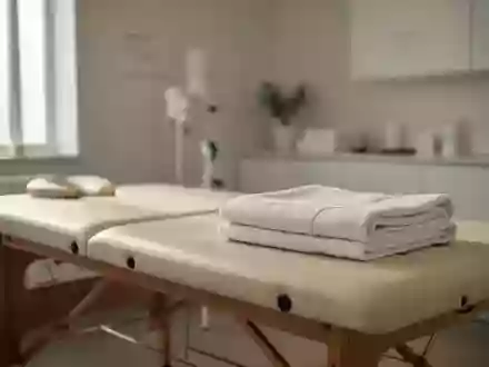 Minimalistisch eingerichteter Physiotherapieraum mit einer Behandlungsliege und einem gefalteten Handtuch in natürlichem Licht. - Foto: über boerse-global.de