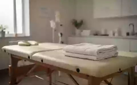 Minimalistisch eingerichteter Physiotherapieraum mit einer Behandlungsliege und einem gefalteten Handtuch in natürlichem Licht. - Foto: über boerse-global.de