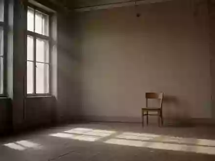 Ein minimalistischer, leerer Warteraum mit hohen Fenstern, schlichtem Holzstuhl und diffusem Tageslicht in einem Altbau. - Foto: über boerse-global.de