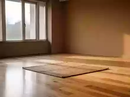 Ein minimalistisch gestalteter, lichtdurchfluteter Raum mit einer Yogamatte auf einem Holzboden in ruhiger Atmosphäre. - Foto: über boerse-global.de