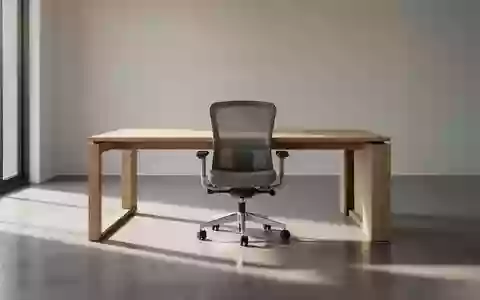 Ein minimalistischer, leerer Arbeitsbereich mit einem Holztisch und einem ergonomischen Stuhl in natürlichem Licht. - Foto: über boerse-global.de