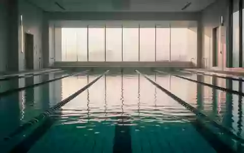 Ein ruhiges, minimalistisches Schwimmbecken in einer modernen Sportanlage bei natürlichem Licht. - Foto: über boerse-global.de