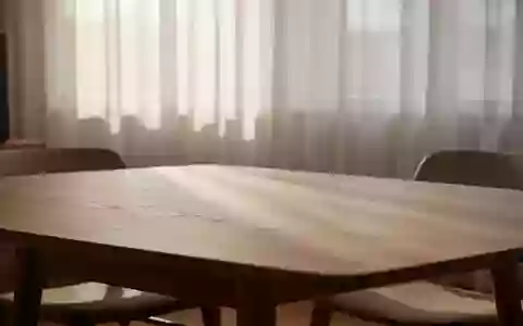 Ein minimalistisch eingerichteter, lichtdurchfluteter Raum mit Fokus auf die Texturen von Holzmöbeln und natürlichem Licht. - Foto: über boerse-global.de