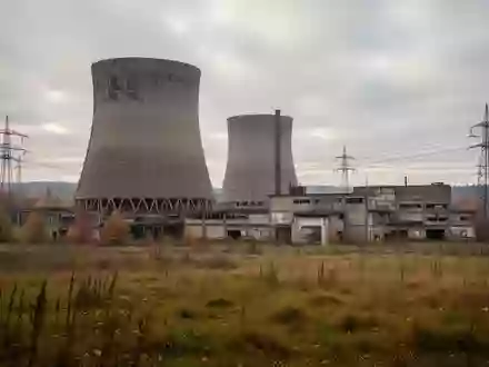 Ein stillgelegtes Kraftwerksgelände mit Kühltürmen und Strommasten in einer weiten Industrielandschaft. - Foto: über boerse-global.de