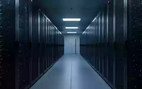 Ein moderner, minimalistischer Serverraum mit dunklen Metallschränken in einer kühlen blauen Beleuchtung. - Foto: über boerse-global.de