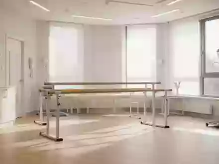Ein heller, moderner Therapieraum mit hölzernem Boden und einer Barrenanlage für die physiotherapeutische Rehabilitation. - Foto: über boerse-global.de
