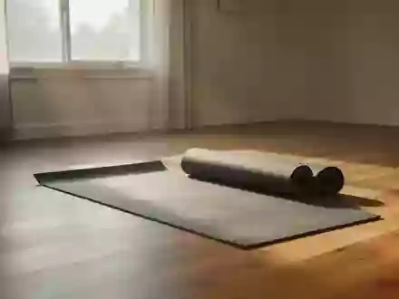 Ein sonnendurchfluteter Raum mit einer ausgerollten Yogamatte auf einem Holzboden, der Bewegung und Genesung symbolisiert. - Foto: über boerse-global.de