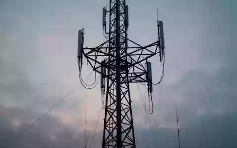 Ein Funkturm vor einem bewölkten Abendhimmel als Symbol für Mobilfunkinfrastruktur. - Foto: über boerse-global.de