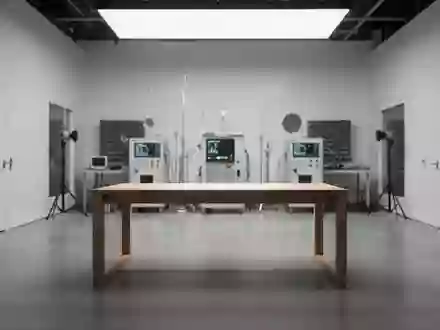 Ein minimalistischer, leerer Arbeitstisch in einem modernen Elektronik-Labor mit unscharfen Messgeräten im Hintergrund. - Foto: über boerse-global.de