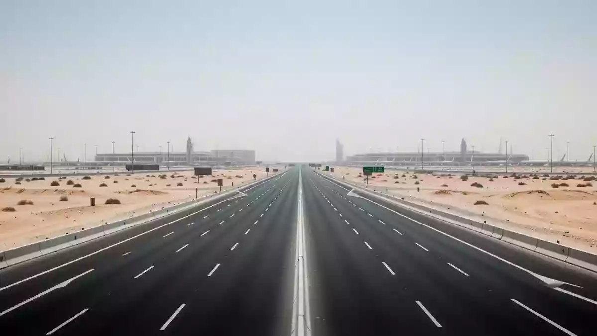 Eine leere, mehrspurige Autobahn in Dubai bei hellem Tageslicht, umgeben von einer weiten Wüstenlandschaft. Illustration mit AI erstellt.