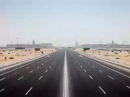 Eine leere, mehrspurige Autobahn in Dubai bei hellem Tageslicht, umgeben von einer weiten Wüstenlandschaft. - Foto: über boerse-global.de