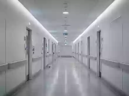 Ein leerer, modern gestalteter Krankenhausflur mit hellen Wänden und indirekter Beleuchtung. - Foto: über boerse-global.de