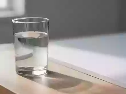 Ein Glas Wasser auf einer hellen Holzoberfläche in natürlichem Morgenlicht als Symbol für gesundheitliche Routine. - Foto: über boerse-global.de