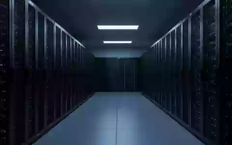 Eine minimalistische, moderne Serverlandschaft in einem dunklen, in kühles Licht getauchten Rechenzentrum ohne Personen. - Foto: über boerse-global.de