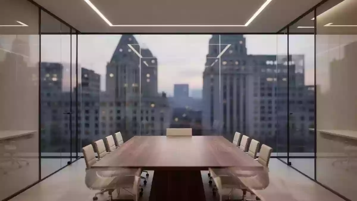 Ein minimalistischer, moderner Büro-Konferenzraum mit Blick auf eine urbane Skyline bei Dämmerung. Illustration mit AI erstellt.
