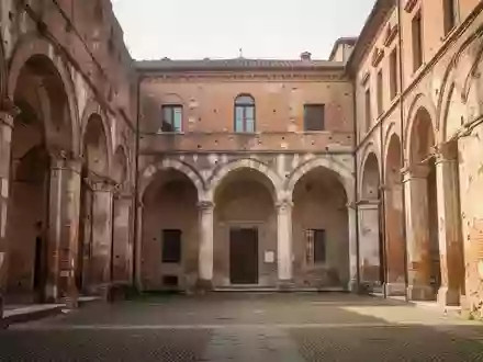 Ein sonnendurchfluteter, historischer Innenhof mit alten Backsteinmauern und Rundbögen in Piacenza. - Foto: über boerse-global.de