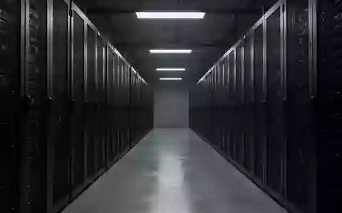 Ein langer, leerer Flur in einem Rechenzentrum mit dunklen Serverracks, die in einer kühlen, professionellen Atmosphäre stehen. - Foto: über boerse-global.de