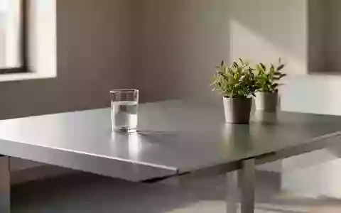 Ein minimalistischer, heller Arbeitsplatz mit einer leeren Glasoberfläche und einer kleinen Pflanze in einem ruhigen Raum. - Foto: über boerse-global.de