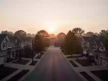 Eine ruhige Wohnstraße in einem Vorort bei Sonnenuntergang, die die Architektur von Einfamilienhäusern zeigt. - Foto: über boerse-global.de
