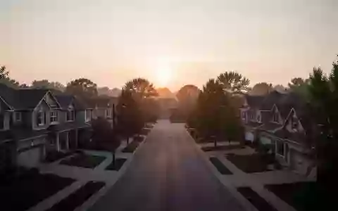 Eine ruhige Wohnstraße in einem Vorort bei Sonnenuntergang, die die Architektur von Einfamilienhäusern zeigt. - Foto: über boerse-global.de