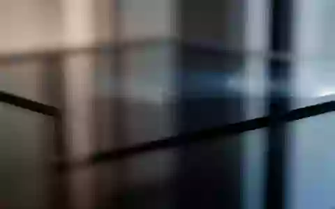 Abstrakte, dunkle Glasoberfläche mit weichen Lichtreflexionen als Symbol für digitale Privatsphäre und Datensicherheit. - Foto: über boerse-global.de