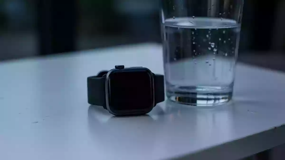 Symbolbild: Smartwatch neben einem Glas Wasser Illustration mit AI erstellt.