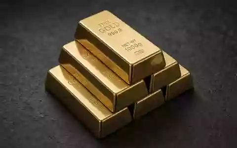 Gestapelte Goldbarren auf einer dunklen, texturierten Oberfläche in natürlichem Licht. - Foto: über boerse-global.de